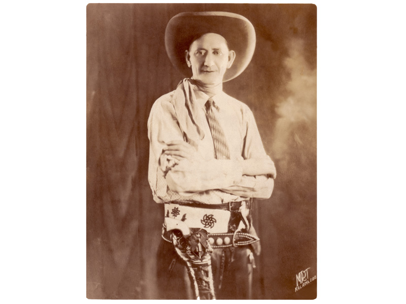Studio portrait of Bee Ho with his Comanche beaded belt, Colt pistol and throwing knife, circa 1925.
